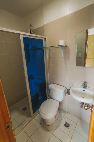 a bathroom with a toilet and a sink at Villa de Gloria in Dauis