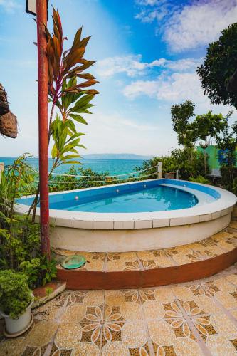 a large swimming pool with the ocean in the background at Villa de Gloria in Dauis