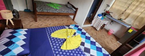 a bedroom with a bed with a checkered blanket at Apartahotel & Gym Rondon in Tortuguero