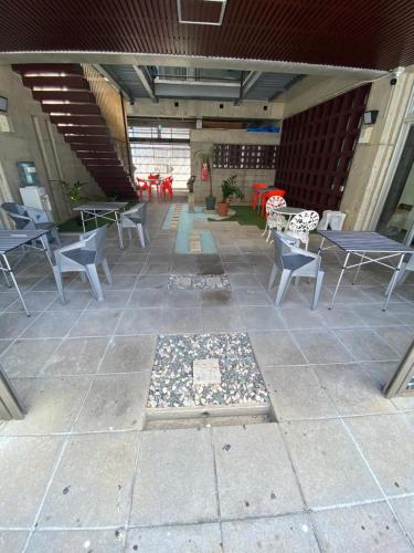 an empty patio with tables and chairs in a building at ゲストハウスUYokinawa in Uruma