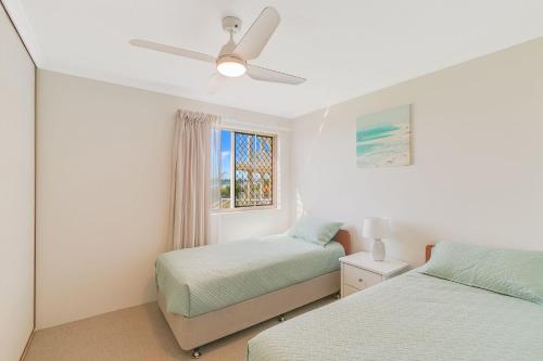 a bedroom with two beds and a ceiling fan at Pacific Gables 1 in Gold Coast