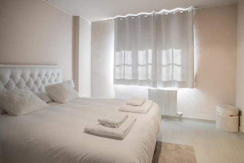 a bedroom with a white bed with towels on it at Comodidad y estilo en Gava near the beach 10 minutes in Viladecáns