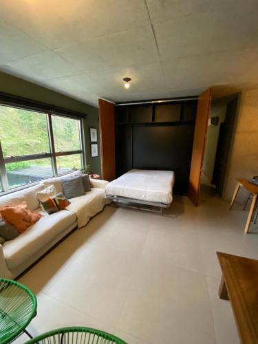 a living room with a couch and a bed at Apartamento praia brava in Itajaí
