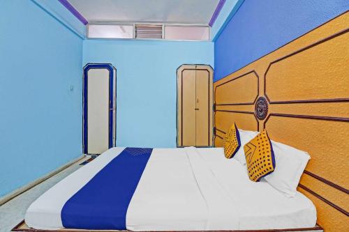 a bedroom with a large bed with blue walls at SPOT ON Sahara lodge in Bengaluru