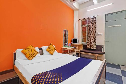 a bedroom with a bed and a desk and a chair at SPOT ON Sahara lodge in Bengaluru