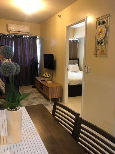 a living room with a dining table and a bedroom at Majestic One Bedroom Condo Unit in Iloilo City
