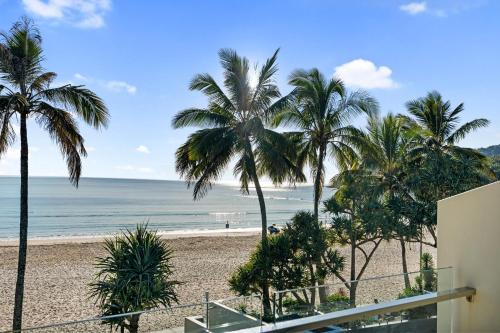 a view of a beach with palm trees and the ocean at Fairshore Noosa in Noosa Heads