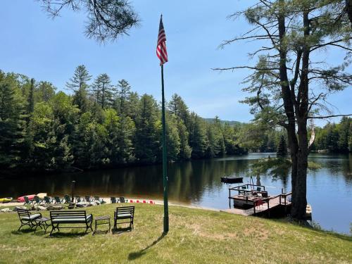 a pole with an american flag next to a lake at Mountain Retreat on Private Lake-Alderbrook Lodge in Bolton