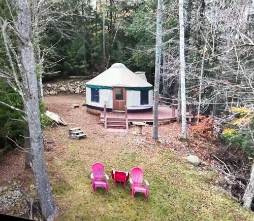a yurt in the woods with pink chairs and a tent at Mountain Retreat on Private Lake-Alderbrook Lodge in Bolton