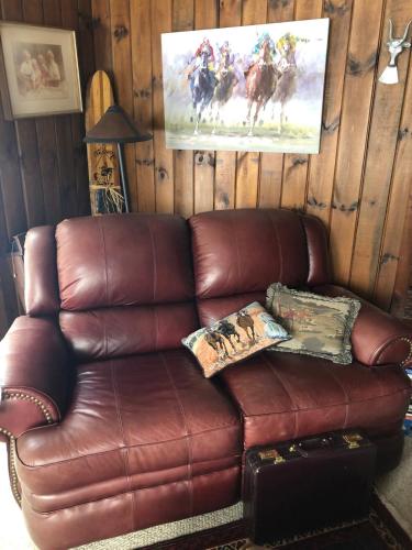a brown leather couch sitting in a living room at Chalet on Private Alderbrook Lake in Bolton