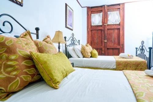 a bedroom with two beds and a door at Hotel Los Balcones Leon in León