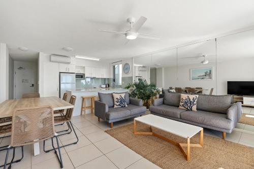 a living room with a couch and a table at Fairshore Noosa in Noosa Heads