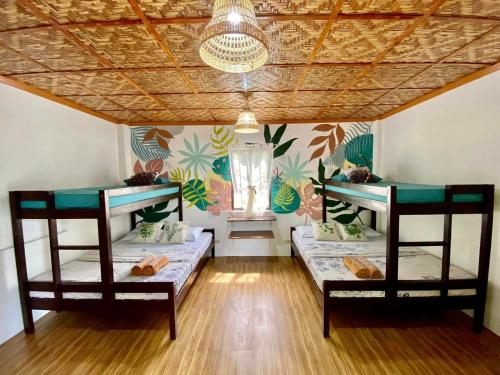 two beds in a room with a ceiling at Casa Aleli Cebu in Ginatilan