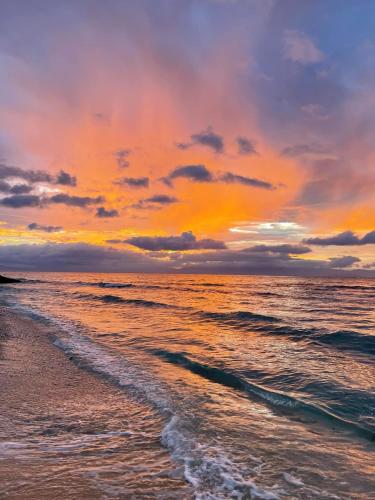 a sunset on the beach with the ocean and clouds at Casa Aleli Cebu in Ginatilan