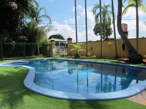 a swimming pool with blue water in a yard at Paravista Motel in Darwin