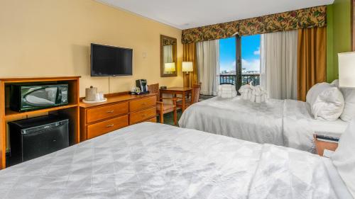 a hotel room with two beds and a television at Holiday Inn & Suites Clearwater Beach by IHG in Clearwater Beach