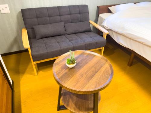 a couch and a table and a chair in a room at 改装済み最大9名まで快適空間 プロジェクター付き1棟貸しの宿 こふみ in Fujikawaguchiko