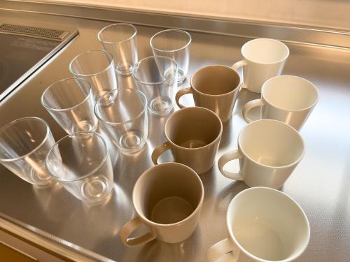 a bunch of empty cups sitting on a counter at 改装済み最大9名まで快適空間 プロジェクター付き1棟貸しの宿 こふみ in Fujikawaguchiko