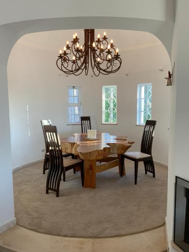 a dining room table with chairs and a chandelier at Villa Lucie vue mer avec piscine privée en Algarve.. in Faro