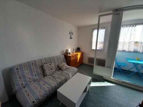 un salon avec un canapé et une table dans l'établissement Charmant T2 à 1min de la plage avec parking privé et commodités à proximité ! - FR-1-324A-69, à Saint-Hilaire-de-Riez