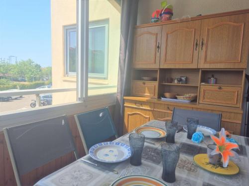 une salle à manger avec une table et une fenêtre dans l'établissement Appartement T2 avec terrasse et parking à 1,3 km de la plage - Cap d'Agde - FR-1-249-419, au Cap d'Agde