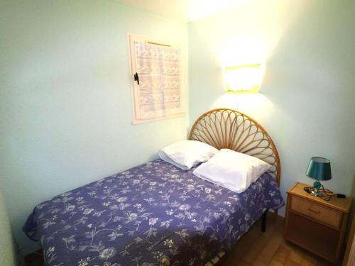 une chambre avec un lit et une lampe sur une table dans l'établissement Appartement 2 pièces avec piscines, proche plage et commerces, parking privé, clim, idéal famille - FR-1-307-273, au Grau-du-Roi