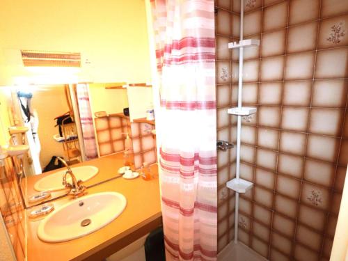 une salle de bain avec un lavabo et un rideau de douche dans l'établissement Appartement 2 pièces avec piscines, proche plage et commerces, parking privé, clim, idéal famille - FR-1-307-273, au Grau-du-Roi