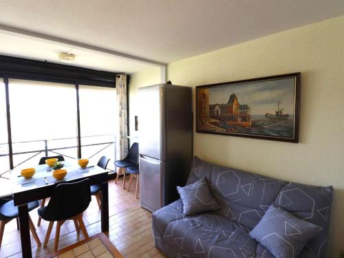 un salon avec un canapé et une table dans l'établissement Appartement 2 pièces avec piscines, proche plage et commerces, parking privé, clim, idéal famille - FR-1-307-273, au Grau-du-Roi