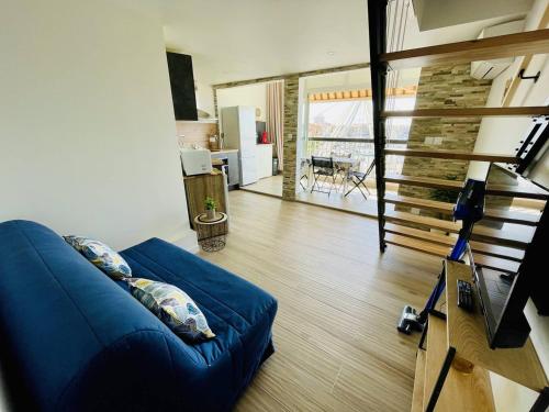 - un salon avec un canapé bleu et un escalier dans l'établissement Bel appartement climatisé en centre-port - FR-1-723-165, au Cap d'Agde