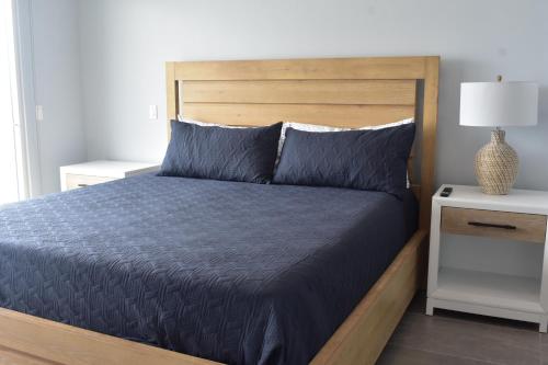 a bedroom with a bed with blue sheets and a nightstand at Ocean View Home Mision Viejo KM50 Gated Security in Rosarito