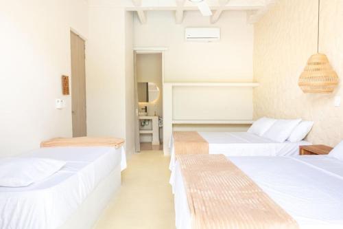 two beds in a room with white walls at Villa privada en coveñas sucre in Coveñas