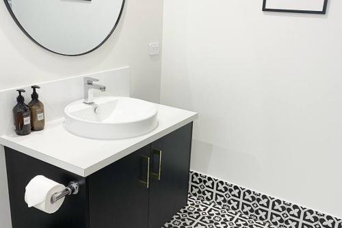 a bathroom with a sink and a mirror at Brand new 4 bedroom home with Golf Views in Yarrawonga