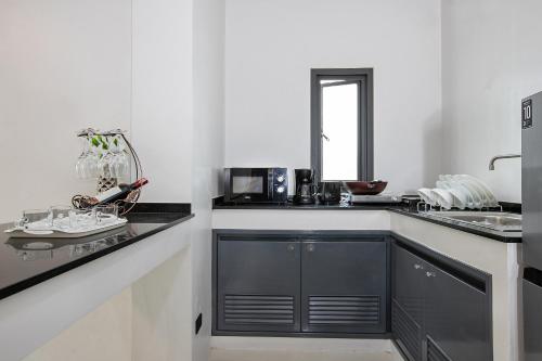 a kitchen with black cabinets and a counter top at Nariya Bayfront Phuket in Ban Bang Chak