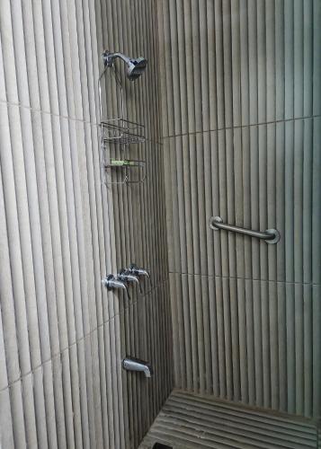 a shower with two faucets on a wall at Sky Beach Hotel in Hopewell