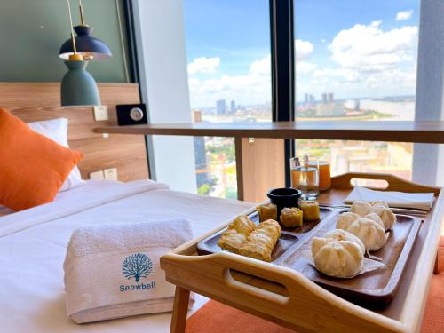 uma bandeja de doces em cima de uma cama em The Snowbell Hotel & Spa at The Bridge em Phnom Penh