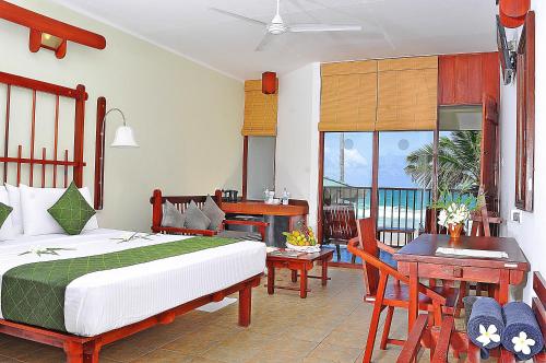 1 dormitorio con cama, escritorio y mesa en Koggala Beach Hotel, en Koggala