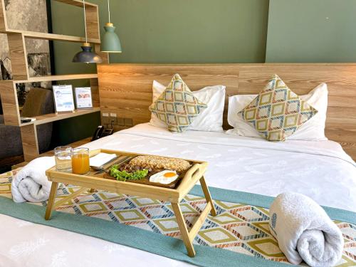 uma cama com uma bandeja de comida em The Snowbell Hotel & Spa at The Bridge em Phnom Penh