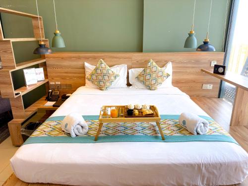 um quarto com uma cama com uma bandeja de comida em cima em The Snowbell Hotel & Spa at The Bridge em Phnom Penh