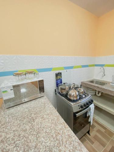 a kitchen with a stove and some pots and pans at Departamento en San Cristóbal a 5 minutos del malecón, con 2 habitaciones, 4 camas, sala de estar, área de comedor, cocina equipada y excelente ubicación - Marysol - Galápagos Home in Puerto Baquerizo Moreno