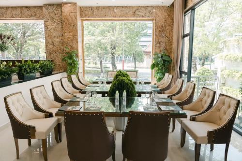 a dining room with a long table and chairs at Menrva Hotel in Hai Phong