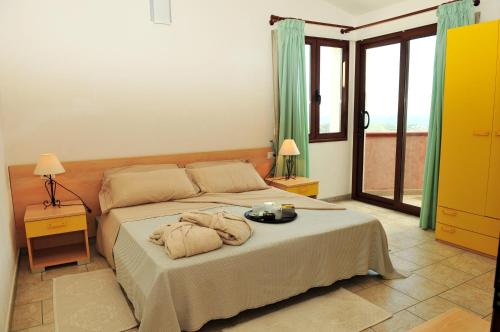 een slaapkamer met een bed met twee handdoeken erop bij Hotel Castello Budoni in Budoni