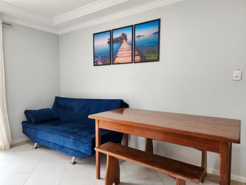 a living room with a blue couch and a table at Apto El Shadday 202 cento e cinqüenta metros do Mar in Bombinhas