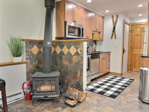 a kitchen with a stove in the middle of a room at CozyDen - AC, Grill, Bike to Mountain, Porch! in Killington