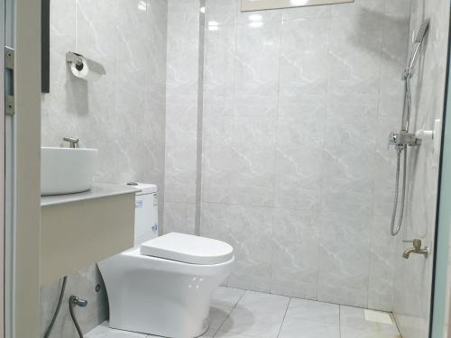 a bathroom with a shower and a toilet and a sink at Isle Inn Guesthouse in Fuvahmulah