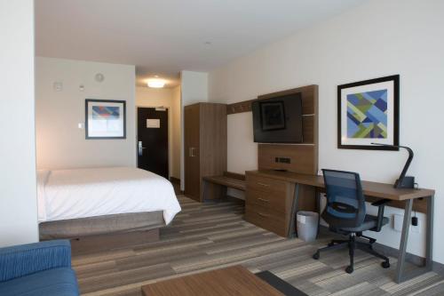 a hotel room with a bed and a desk with a computer at Holiday Inn Express & Suites - Edmonton SW – Windermere by IHG in Edmonton