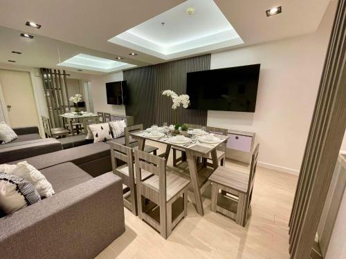 マニラにあるHigh-end 2BR Condo Boracay Tower - Azure Residences near Manila Airportのソファとテーブルと椅子のあるリビングルーム