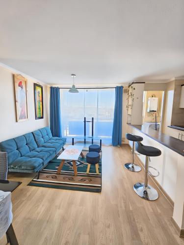 a living room with a blue couch and some chairs at Amplio y Cómodo departamento in Temuco
