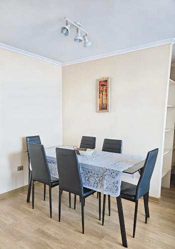a dining room with a table and chairs at Amplio y Cómodo departamento in Temuco