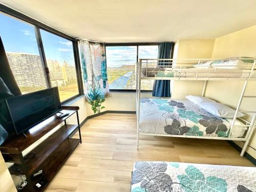 a room with two bunk beds and a flat screen tv at Ocean Canal Mountain View Steps from Waikiki Beach 6person in Honolulu