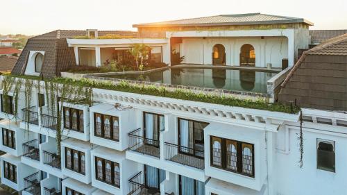 an aerial view of a white building with a swimming pool at Sarai and Wander Resort in Siem Reap